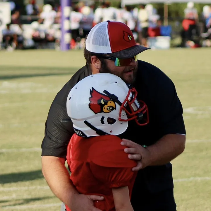 A Four Oaks coach hugging a young player