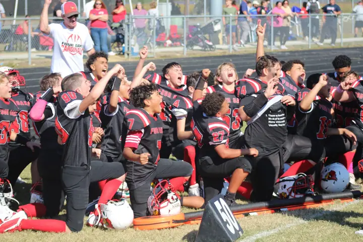 Four Oaks coaches and players on the sideline