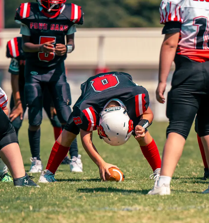A Four Oaks center snapping the ball at practice