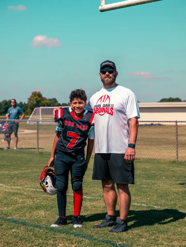 A Four Oaks coach with a young player on the sideline